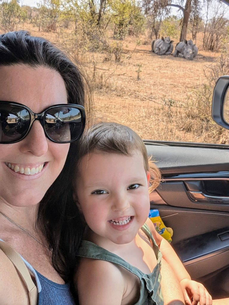 Child on safari with rhinos in background